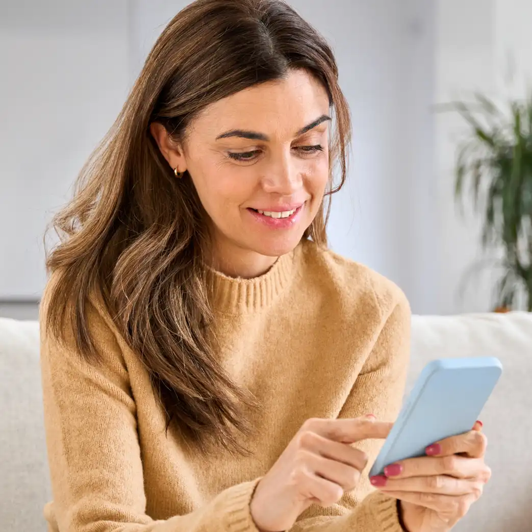 Woman smiling and scrolling on her phone