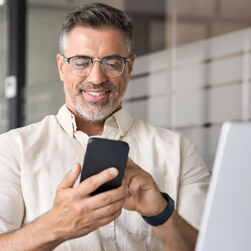 Man smiling and scrolling on his phone