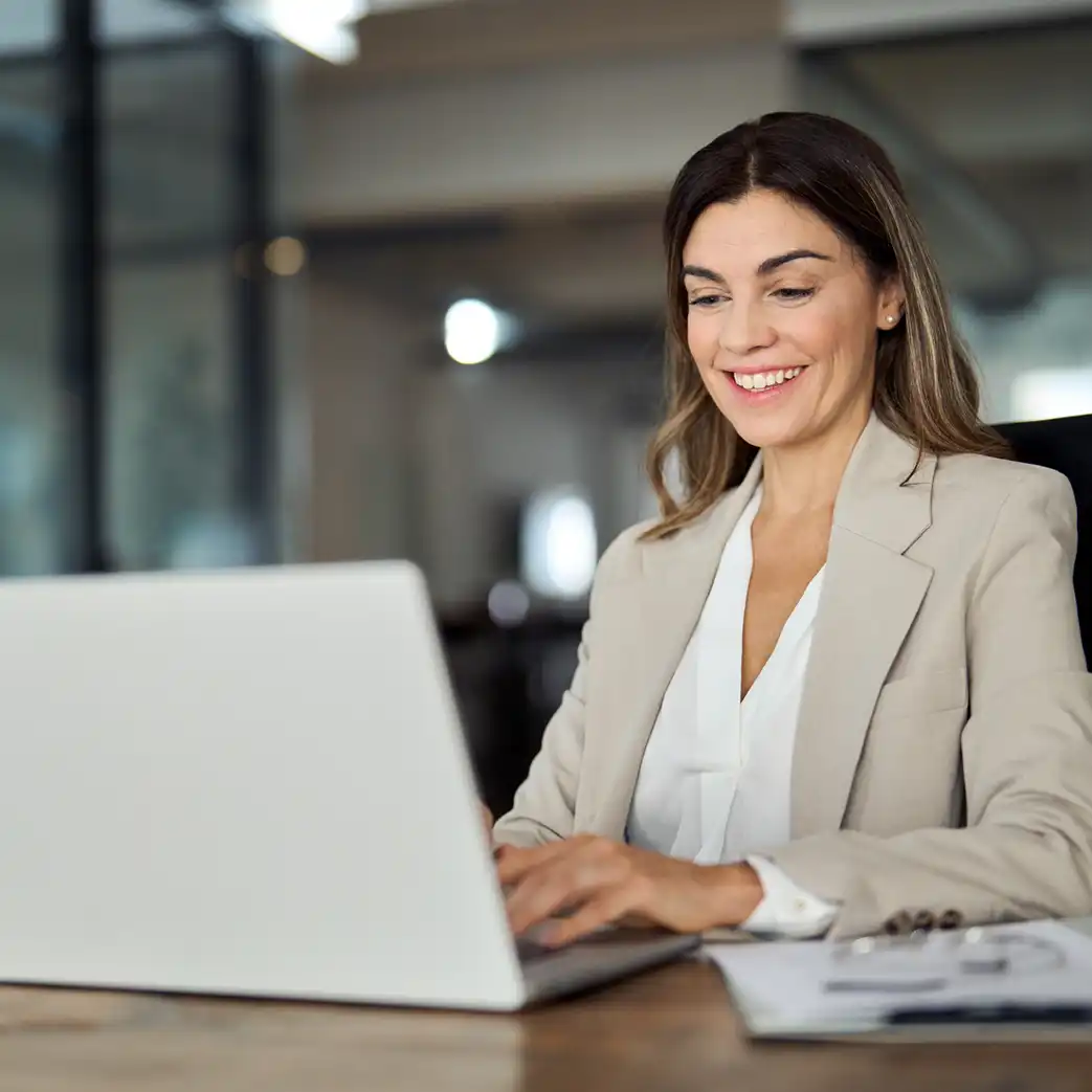 Businesswoman smiling and looking at her laptop