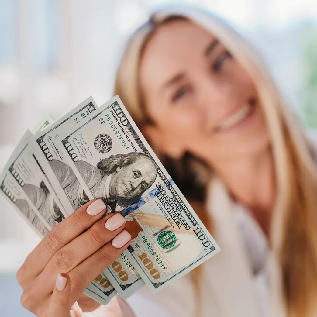 A women holding $500 in cash and smiling